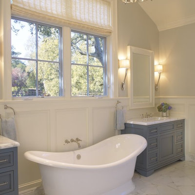 Example of a classic freestanding bathtub design in San Francisco with blue cabinets
