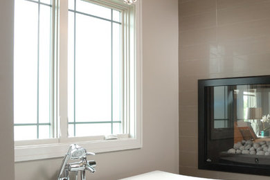 Imagen de cuarto de baño principal contemporáneo de tamaño medio con bañera exenta, paredes marrones, suelo de baldosas de porcelana y suelo beige