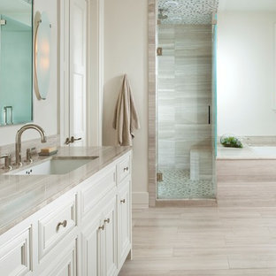 Foto di una stanza da bagno classica con lavabo sottopiano, vasca sottopiano, piastrelle beige, ante bianche, piastrelle di pietra calcarea e top grigio