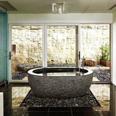 Inspiration for a mid-sized contemporary master black tile and stone tile porcelain tile and black floor bathroom remodel in Austin with white walls, a vessel sink, solid surface countertops, a wall-mount toilet and a hinged shower door