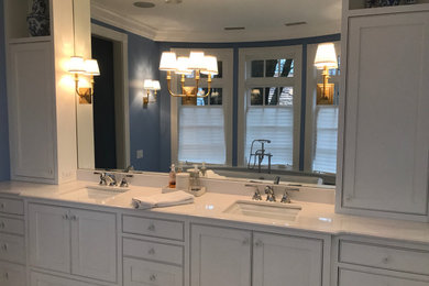 Example of a large transitional master marble floor and gray floor bathroom design in Boston with recessed-panel cabinets, white cabinets, a two-piece toilet, blue walls, an undermount sink, quartz countertops, a hinged shower door and white countertops