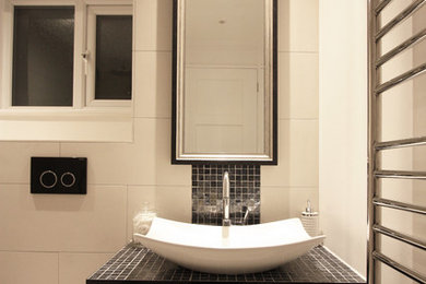 Inspiration for a small contemporary shower room bathroom in London with freestanding cabinets, black cabinets, a walk-in shower, a one-piece toilet, black tiles, glass tiles, white walls, porcelain flooring and tiled worktops.