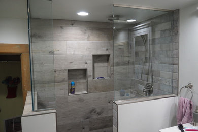 Bathroom - mid-sized transitional 3/4 gray tile and ceramic tile laminate floor and gray floor bathroom idea in Other with shaker cabinets, white cabinets, a two-piece toilet, gray walls, an undermount sink and quartz countertops