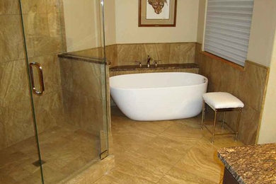 Example of a large classic master beige tile bathroom design in Denver with an undermount sink, raised-panel cabinets, medium tone wood cabinets, beige walls and granite countertops