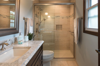 Bathroom - mid-sized transitional master beige tile and porcelain tile porcelain tile and beige floor bathroom idea in Chicago with recessed-panel cabinets, dark wood cabinets, a two-piece toilet, blue walls, an undermount sink and quartz countertops