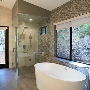 Foto di una stanza da bagno padronale design di medie dimensioni con ante lisce, ante bianche, vasca freestanding, WC sospeso, piastrelle verdi, piastrelle in gres porcellanato, pareti verdi, parquet chiaro, lavabo a bacinella, top in marmo, top giallo, doccia ad angolo, pavimento beige e porta doccia a battente