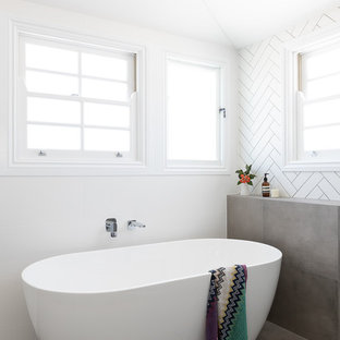 This is an example of a large contemporary master bathroom in Brisbane with shaker cabinets, black cabinets, a freestanding tub, an open shower, a one-piece toilet, black tile, cement tile, white walls, cement tiles, an integrated sink, engineered quartz benchtops, grey floor, an open shower and white benchtops.