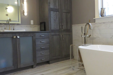 Inspiration for a large contemporary master multicolored tile and porcelain tile porcelain tile and multicolored floor bathroom remodel in Portland Maine with glass-front cabinets, gray cabinets, a wall-mount toilet, gray walls, a drop-in sink, quartz countertops and a hinged shower door