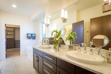 Photo of a large modern ensuite bathroom in Other with flat-panel cabinets, dark wood cabinets, a freestanding bath, white tiles, white walls, ceramic flooring, a vessel sink and marble worktops.