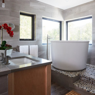 Bathroom - small asian master gray tile and porcelain tile medium tone wood floor and brown floor bathroom idea in DC Metro with furniture-like cabinets, gray cabinets, white walls, quartz countertops, a hinged shower door and gray countertops