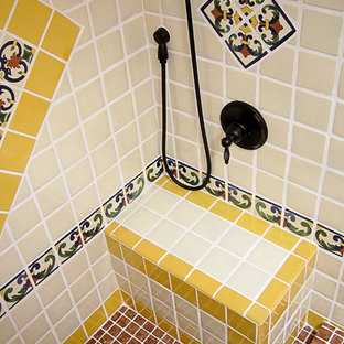 Inredning av ett amerikanskt mellanstort badrum med dusch, med luckor med upphöjd panel, skåp i ljust trä, en dusch i en alkov, en toalettstol med hel cisternkåpa, blå kakel, vit kakel, gul kakel, keramikplattor, vita väggar, tegelgolv, ett integrerad handfat, kaklad bänkskiva, rött golv och dusch med duschdraperi