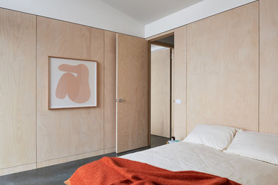 Imagen de habitación de invitados contemporánea con paredes beige, suelo de cemento y suelo gris