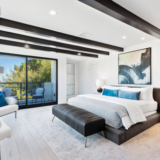 Modernes Schlafzimmer mit weißer Wandfarbe, braunem Holzboden, braunem Boden und freigelegten Dachbalken in Los Angeles