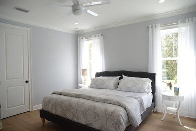 Mid-sized elegant master light wood floor bedroom photo in Orlando with gray walls