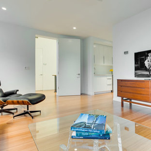 Imagen de dormitorio tipo loft, actual, grande, con paredes blancas y suelo de bambú