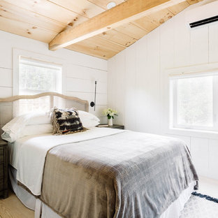 Imagen de habitación de invitados campestre, pequeña, con paredes blancas, suelo de madera clara, estufa de leña y suelo blanco