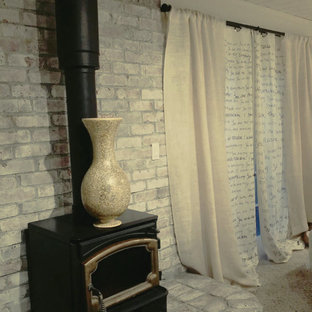 Diseño de dormitorio principal, retro, grande, con paredes blancas, moqueta, estufa de leña y marco de chimenea de ladrillo