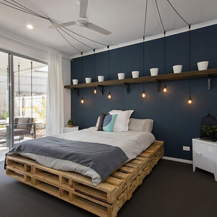 Photo of an industrial bedroom in Sunshine Coast with blue walls, carpet and grey floor.