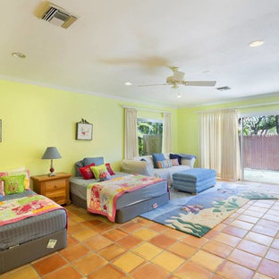 Imagen de dormitorio tipo loft, tropical, de tamaño medio, sin chimenea, con paredes verdes, suelo de baldosas de terracota y suelo multicolor