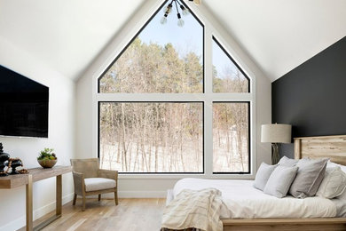 Imagen de habitación de invitados escandinava sin chimenea con paredes blancas, suelo de madera clara y suelo beige