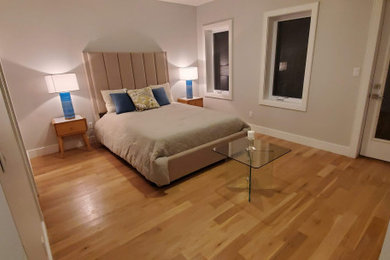 Example of a mid-sized minimalist master light wood floor and yellow floor bedroom design in New York with beige walls