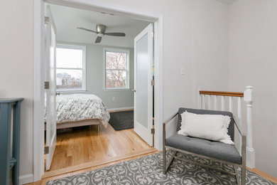 Diseño de dormitorio principal moderno de tamaño medio con paredes grises, suelo de madera clara y suelo beige