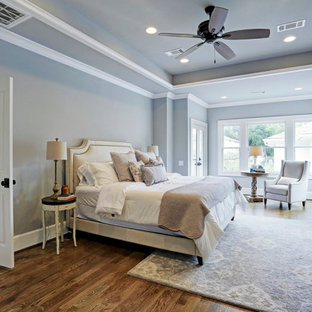 Geräumiges Landhausstil Hauptschlafzimmer mit grauer Wandfarbe, braunem Holzboden, braunem Boden und Kassettendecke in Houston