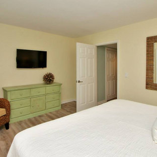 Mittelgroßes Maritimes Hauptschlafzimmer mit gelber Wandfarbe, Laminat und braunem Boden in Sonstige