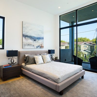 Example of a large trendy master light wood floor and brown floor bedroom design in Los Angeles with white walls and no fireplace