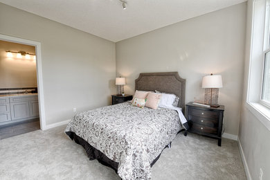 Mid-sized minimalist guest carpeted and beige floor bedroom photo in Calgary with beige walls