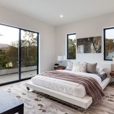Trendy light wood floor and beige floor bedroom photo in Los Angeles with white walls