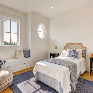 Maritimes Schlafzimmer mit weißer Wandfarbe, braunem Holzboden, braunem Boden und Holzdielenwänden in Los Angeles