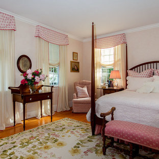 Example of a mid-sized classic guest medium tone wood floor bedroom design in New York with beige walls and no fireplace
