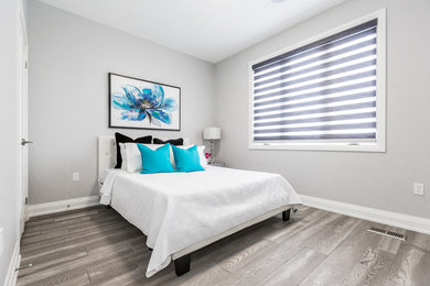 Modelo de habitación de invitados moderna con paredes blancas y suelo de madera clara