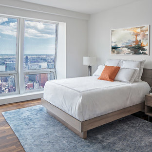 Bedroom - small contemporary dark wood floor and brown floor bedroom idea in New York with white walls