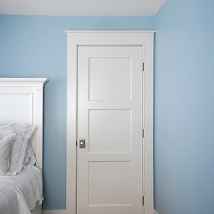 Foto de dormitorio principal, costero, grande, con paredes azules, suelo de madera oscura, chimenea lineal, marco de chimenea de yeso y suelo marrón