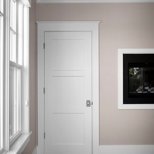 Immagine di una grande camera matrimoniale stile marinaro con pareti beige, parquet scuro, camino lineare Ribbon, cornice del camino in intonaco e pavimento marrone