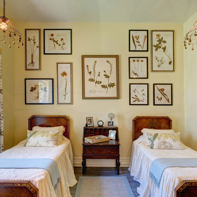 Example of a mid-sized country guest medium tone wood floor bedroom design in Austin with yellow walls and no fireplace