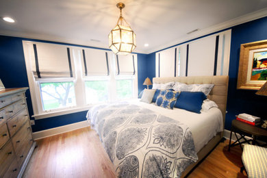 Example of a mid-sized master light wood floor and brown floor bedroom design in St Louis with blue walls and no fireplace
