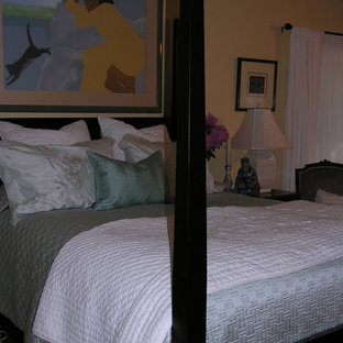 Imagen de dormitorio principal, clásico, con paredes amarillas y suelo de travertino
