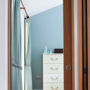 Modelo de habitación de invitados campestre, extra grande, con paredes azules, suelo de madera clara y suelo amarillo