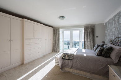 На фото: хозяйская спальня среднего размера в классическом стиле с серыми стенами, ковровым покрытием и бежевым полом без камина с