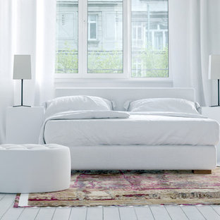 Idee per una grande camera matrimoniale nordica con pareti bianche, pavimento in legno verniciato, camino classico, cornice del camino in intonaco e pavimento bianco