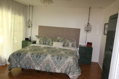Modelo de dormitorio principal tradicional de tamaño medio sin chimenea con paredes blancas, suelo de baldosas de porcelana y suelo marrón