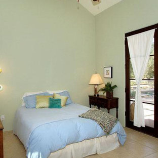 Modelo de habitación de invitados mediterránea, de tamaño medio, con paredes verdes y suelo de travertino