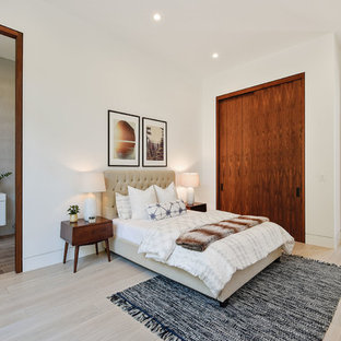 Example of a large trendy master light wood floor and beige floor bedroom design in Los Angeles with white walls