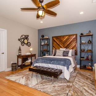 Diseño de habitación de invitados industrial, grande, sin chimenea, con paredes azules y suelo de madera clara