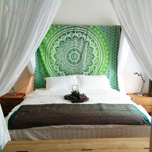 Ejemplo de dormitorio principal, ecléctico, de tamaño medio, con paredes blancas, suelo laminado y suelo marrón