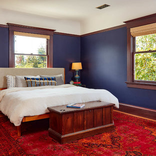 Modelo de dormitorio tradicional con paredes azules, suelo de madera en tonos medios y suelo marrón