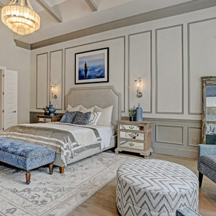 Réalisation d'une grand chambre parentale tradition avec un mur gris, un sol en bois brun, aucune cheminée, un sol marron, un plafond voûté et boiseries.